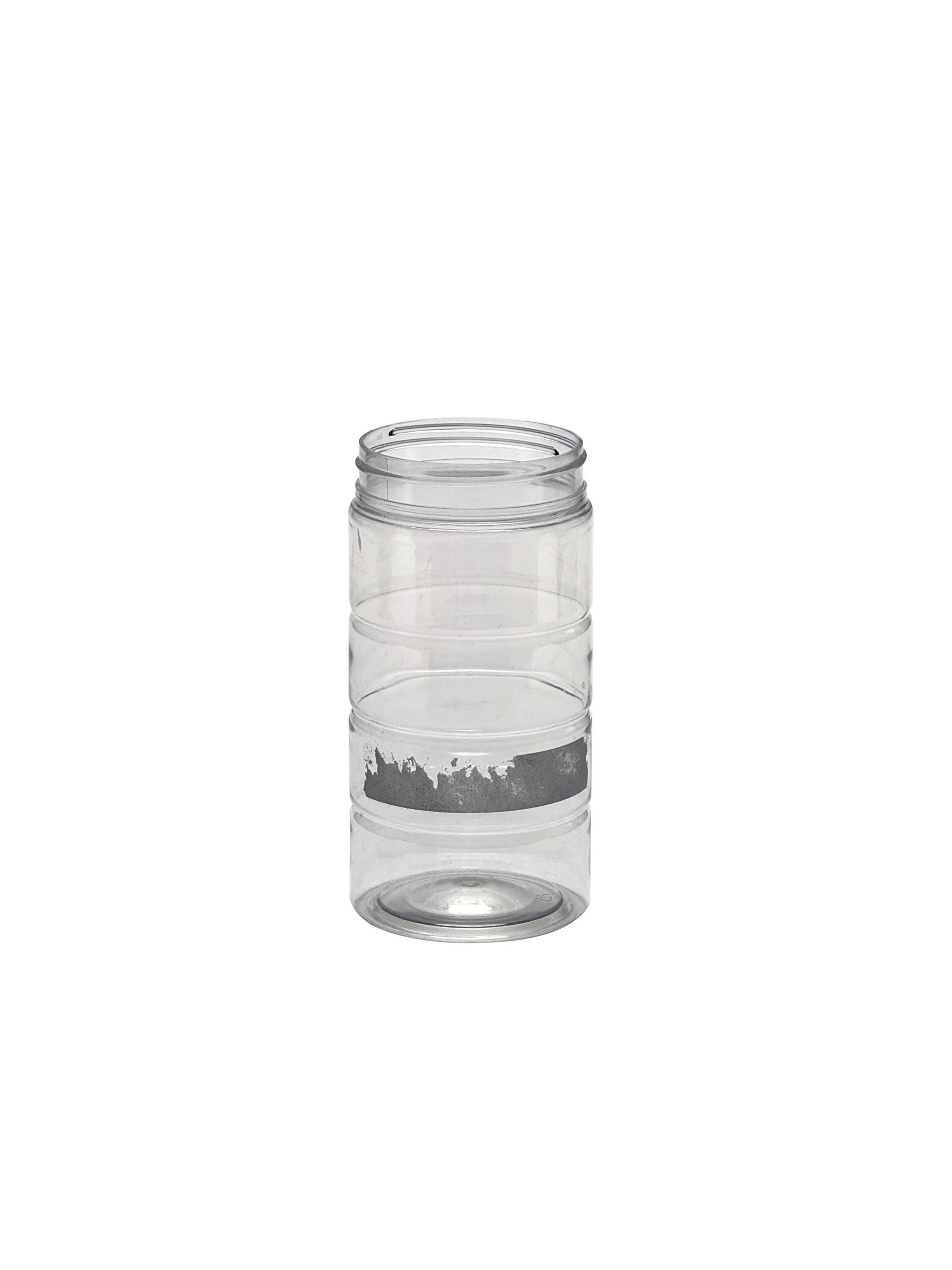 Clear glass candle holder with a label on a white background